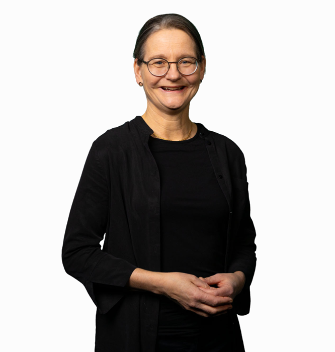 Glad Ulrika i halvbild tittar in i kameran och ser ut att gestikulera med händerna.
